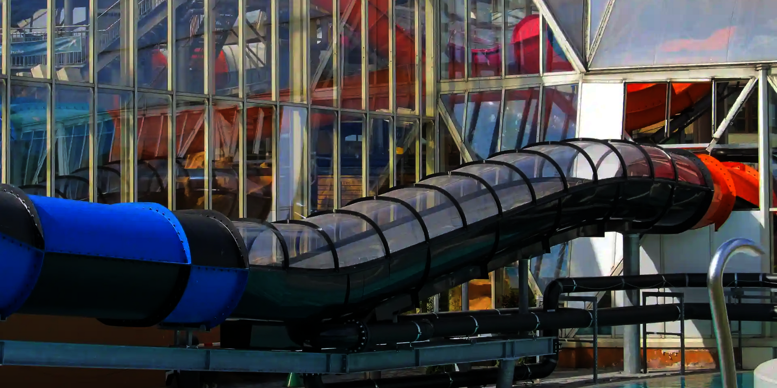 Der schwarze Speed Blaster mit transparentem Dach führt vom Gebäude in ein Außenbecken.