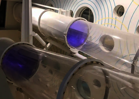 Acryl-Elemente einer weißen Wasserrutsche mit violettem Licht in modernem Innenraumdesign auf der AIDAprima.