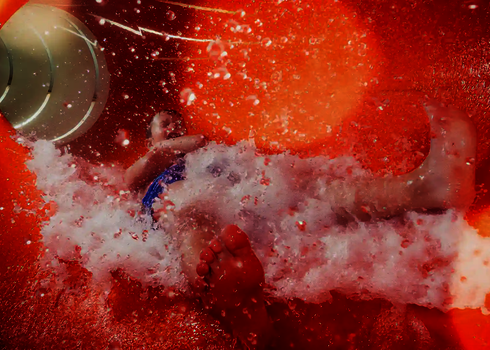 Innenansicht einer roten Wasserrutsche mit rutschendem Kind.