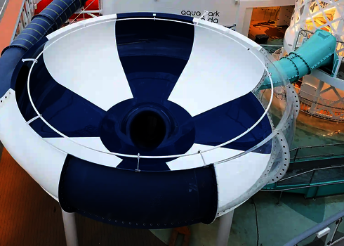 Seitenansicht des Body Bowl auf Kreuzfahrtschiff mit weißem Geländer und blauem Rutschenrohr.