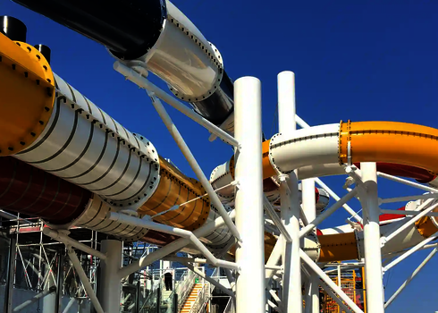 Mehrere bunte Wasserrutschen befinden sich unter freiem Himmel auf einem Kreuzfahrtschiff.