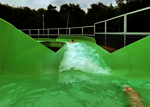 Eine Person treibt mit Kamera durch ein stark strömendes Gefälle der Wildwasserbahn.