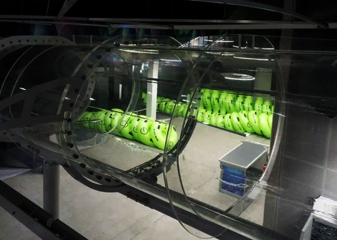 Leeres Acryl-Element einer Wasserrutsche in einer Halle mit aufgestapelten Reifen.