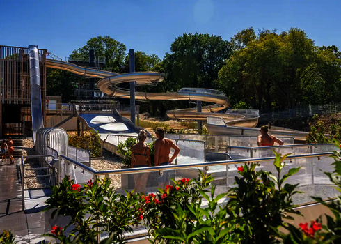 Wasserpark mit einem Freifall, einer WR1040 und einer Breitwellenrutsche umgeben von Pflanzen und Bäumen.