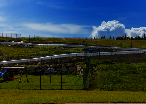 Lange WR1040 Wasserrutsche verläuft durch hügelige Landschaft.