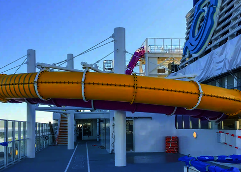 Gelbe und pinke RR900 Wasserrutsche auf dem Deck eines Kreuzfahrtschiffs.