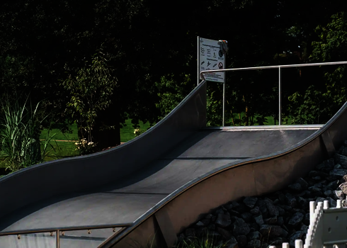 Eine Breitwellenrutsche aus Edelstahl, im Hintergrund eine Hinweistafel.