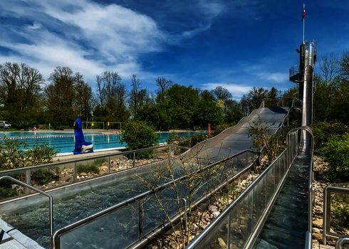 Langer Auslaufbereich aus Edelstahl an einer steilen Freifallrutsche im Freibad.