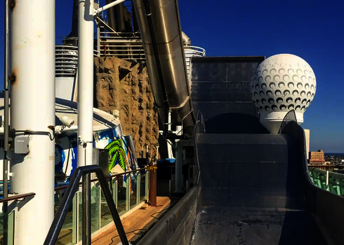 Endstück der Boomerang-Rutsche auf einem Kreuzfahrtschiff mit Skyline im Hintergrund.