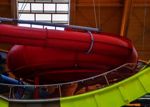 Rote Body Bowl Wasserrutsche in einem Hallenbad.