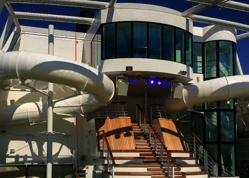 Zwei weiße Röhrenrutschen auf einem Kreuzfahrtschiff unter freiem Himmel.