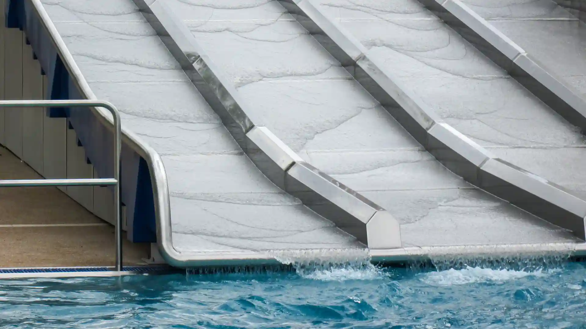 Nahaufnahme des Auslaufs der Multilane im Freibad mit spritzendem Wasser.